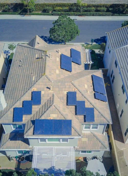 pexels-photo-9875683-9875683 Aerial view of suburban homes equipped with solar panels in a sunny neighborhood.